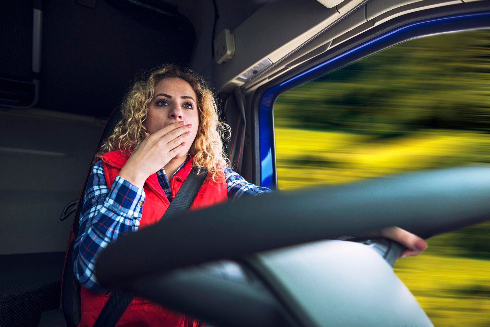 camionera-bostezando-debido-al-cansancio-aburrimiento-mientras-conduce-camion_342744-277